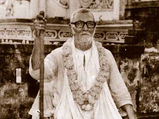 Srila-Sridhar-Maharaj-Seated-with-Staff